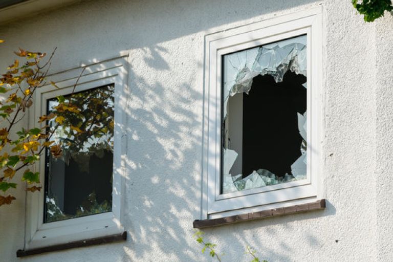 A broken window creating an immediate security risk - an example of an emergency repair requiring urgent attention.
